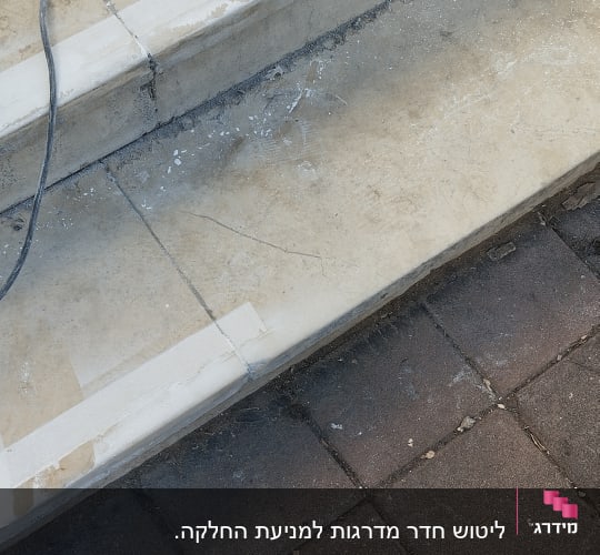 מדרגות אבן עם כבל חשמלי ולכלוך על הרצפה